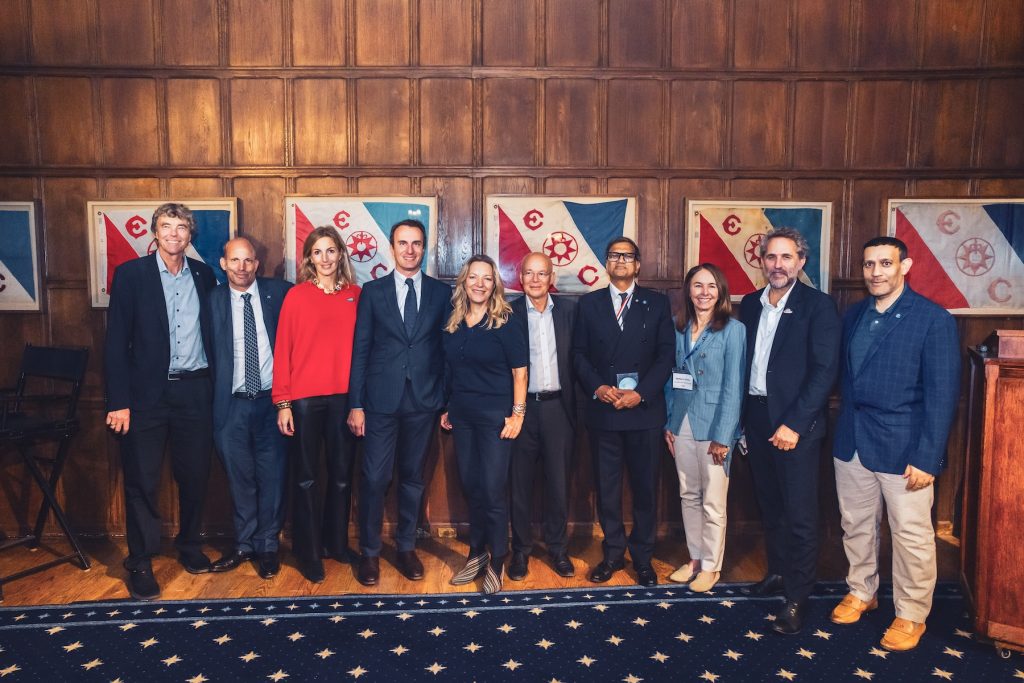 Ten leaders representing a variety of international exploration and science initiatives pose for a photo in a conference room inside a historical museum.