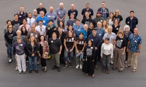 Forty-eight participants in a scientific workshop pose for a group photo in a parking lot.