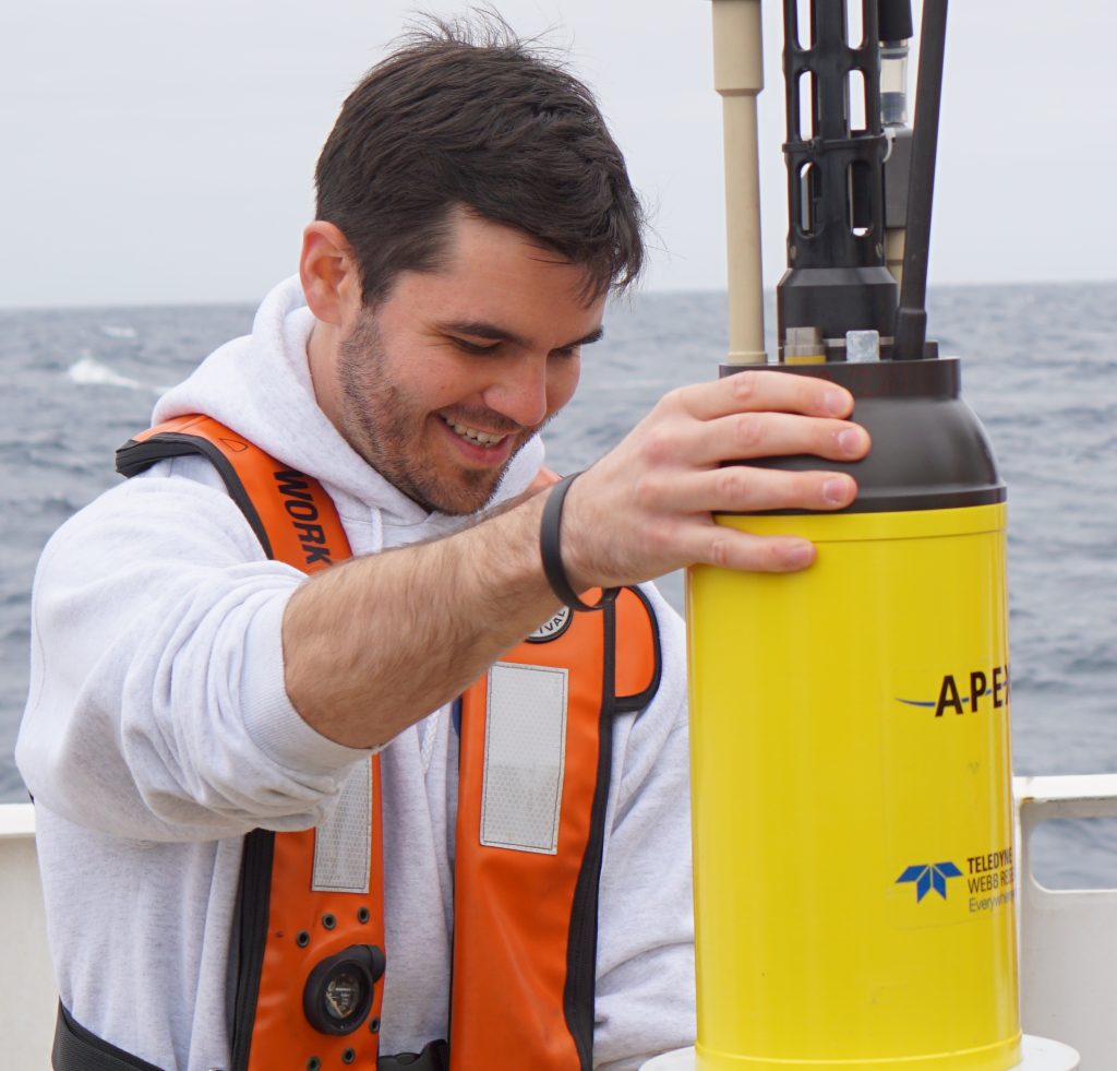 photo showing Jon Sharp holding onto an Apex float while at sea.