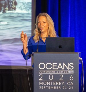 A scientist standing behind a podium gives a keynote address during a scientific conference.