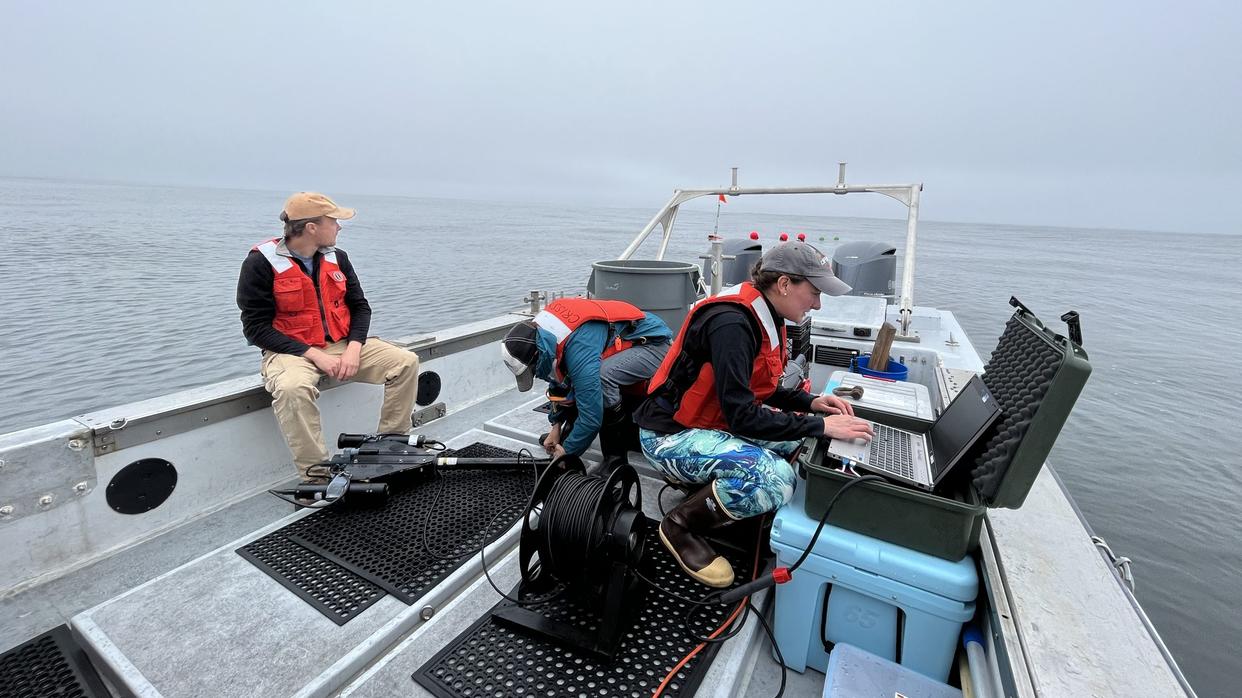 Sasha Kramer preparing a hyperpro radiometer on board the Paragon, along with other members of the Carbon Flux Ecology team.